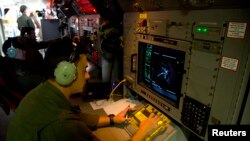 Sersan Matthew Falanga, analis elektronik udara, mengamati gambar radar di atas pesawat AP-3C Orion milik Angkatan Udara Australia dalam pencarian pesawat Malaysian Airlines penerbangan MH370 di atas Samudera Hindia (27/3). 