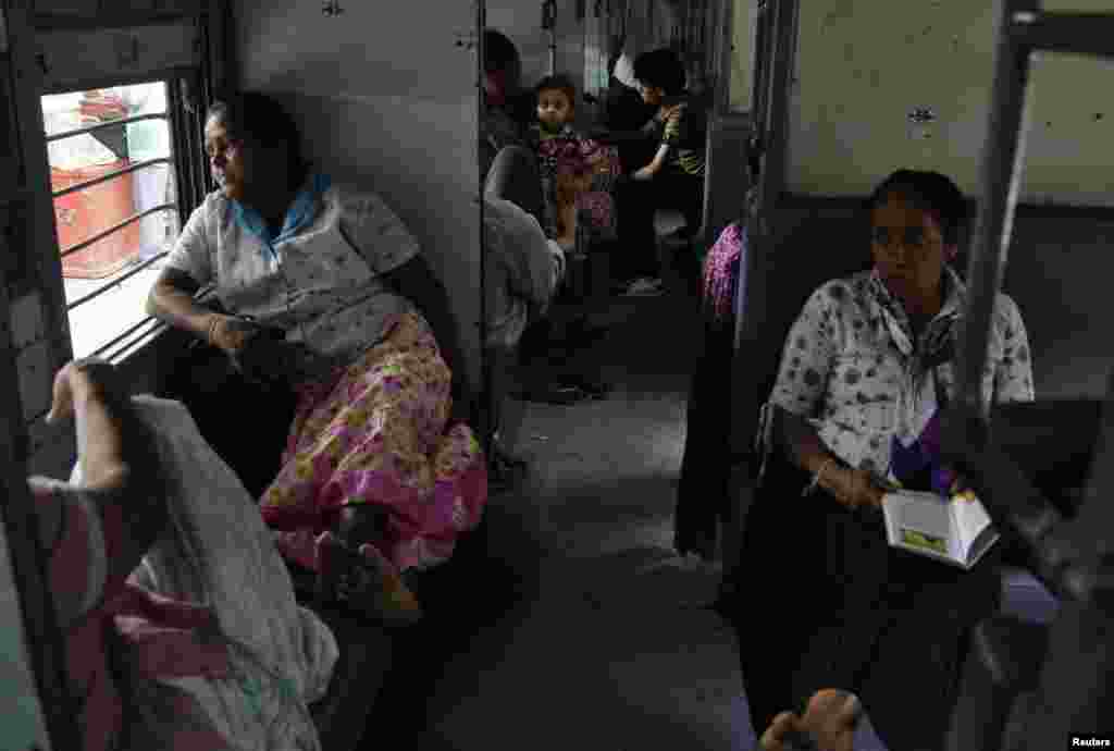 Passengers sit in a train as they wait for electricity to be restored at a railway station in the northern Indian city of Allahabad, July 30, 2012. 