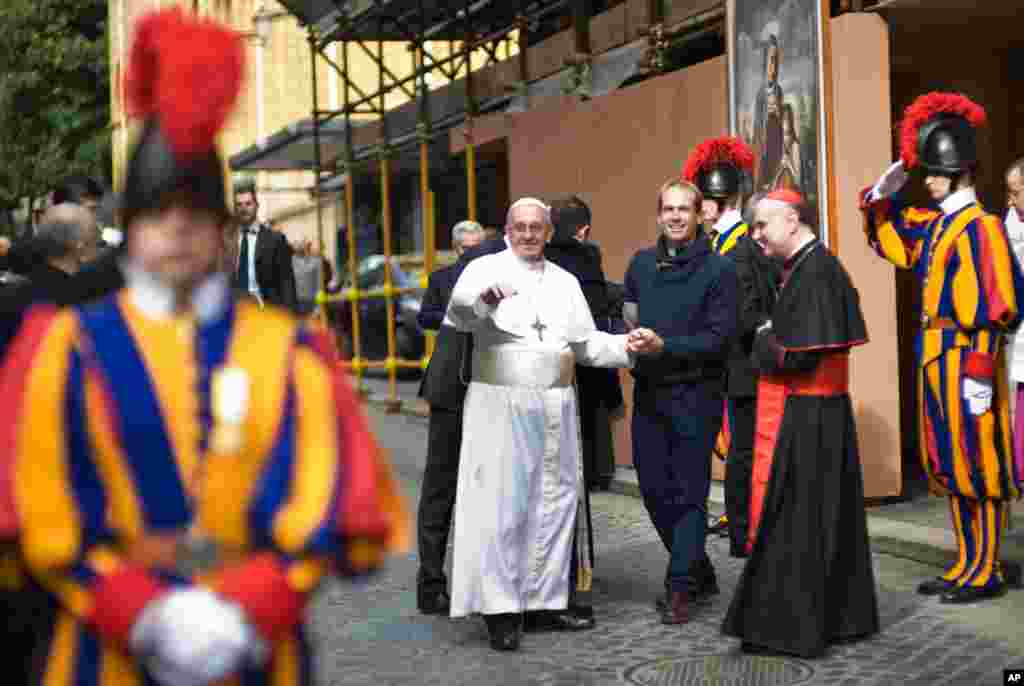 Pope Francis and Uruguay's priest Gonzalo Aemilius greet people at the Vatican, March 17, 2013.