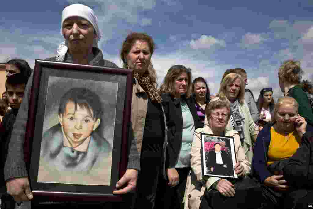 Sabrije Deliu holds a portrait of her 6-year-old son Bleart Deliu, who was killed during the Kosovan war, during a ceremony to mark the 18th anniversary of the killings of dozens Kosovo Albanians by Serbian forces during 1999 Kosovo war, in the village of of Rezalle in the north Kosovo area of Drenica.