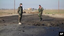In this undated photo made avaialble March 14, 2015, by the Kurdistan Region Security Council, Kurdish soldiers survey what Kurds now say was the site of a chemical-weapons bombing between Mosul, Iraq, and the Syrian border in northern Iraq.