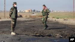 In this undated photo made available March 14, 2015, by the Kurdistan Region Security Council, Kurdish soldiers survey what Kurds now say was the site of a chemical-weapons attack between Mosul, Iraq, and the Syrian border in northern Iraq.