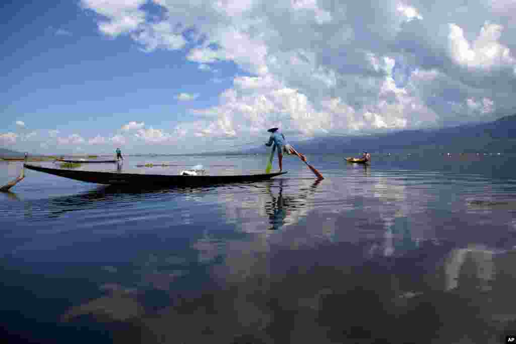 Warga suku Innthas menggunakan perahunya untuk menangkap ikan di Danau Inlay, Nyaung Shwe, Myanmar selatan. 