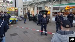 A car stands in front of a store, guarded by police in Heidelberg, Germany, Feb. 25, 2017. A man apparently drove a car into pedestrians in a central square in the city of Heidelberg, injuring three people, then fled and was shot after being tracked down by officers, police said.