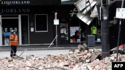 Seorang petugas memeriksa kerusakan sebuah bangunan di Chapel Street, pusat perbelanjaan populer di Melbourne, setelah gempa berkekuatan 5,9 SR mengguncang kawasan tersebut, 22 September 2021. (Foto oleh William WEST / AFP)
