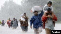 Residents wade through flood waters from Tropical Storm Harvey in Beaumont Place, Houston, Texas, Aug. 28, 2017. 