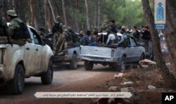FILE - This July 9, 2017, photo — released by Ibaa news agency, the communications arm of the al Qaeda-linked Levant Liberation Committee, that is consistent with independent AP reporting — shows al-Qaida-linked fighters gathering ahead of raids in the northwestern Syrian city of Idlib in search for members of the Islamic State group.