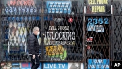 资料照片：新冠疫情期间一名芝加哥市民走过关闭的商店。