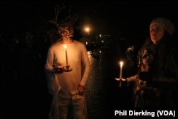 Helvetian festival goers in costume prepare for the masked parade to the community hall.