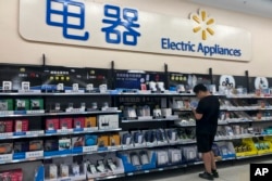 A man looks at digital accessories in Beijing, May 9, 2019. Ratcheting up tension ahead of talks, China vowed Thursday to defend its own interests and retaliate if President Donald Trump goes ahead with more tariff hikes in a dispute over trade and technology.