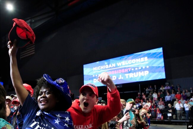 People cheer as President Donald Trump speaks at a rally in Grand Rapids, Michigan, March 28, 2019.