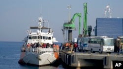 Migran turun dari kapal di pelabuhan Dikili, Turki (6/4).