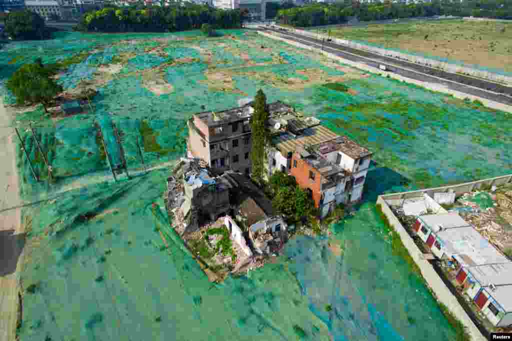 A nail house is seen in the middle of an area covered by a dust screen in Hangzhou, Zhejiang province, China, Sept. 26, 2016.