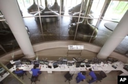 FILE - Asahi Breweries employees work at the central control room at a factory in Moriya near Tokyo, May 29, 2017.