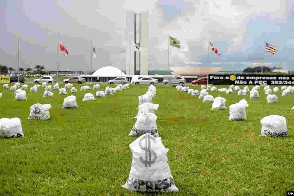 Ratusan kantong uang palsu diletakkan di depan gedung Kongres Nasional di Brasilia sebagai bagian dari aksi protes atas sumbangan perusahaan-perusahaan besar bagi kampanye pemilu di negara tersebut.&nbsp;