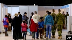 FILE - Syrian refugees wait at Marka Airport in Amman, Jordan, to complete their migration procedures to Canada, Dec. 8, 2015.