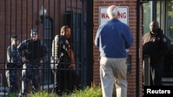 A Navy Yard personnel approaches a security checkpoint as he returns to work two days after a gunman killed 12 people before police shot him dead, in Washington, Sept. 18, 2013. 