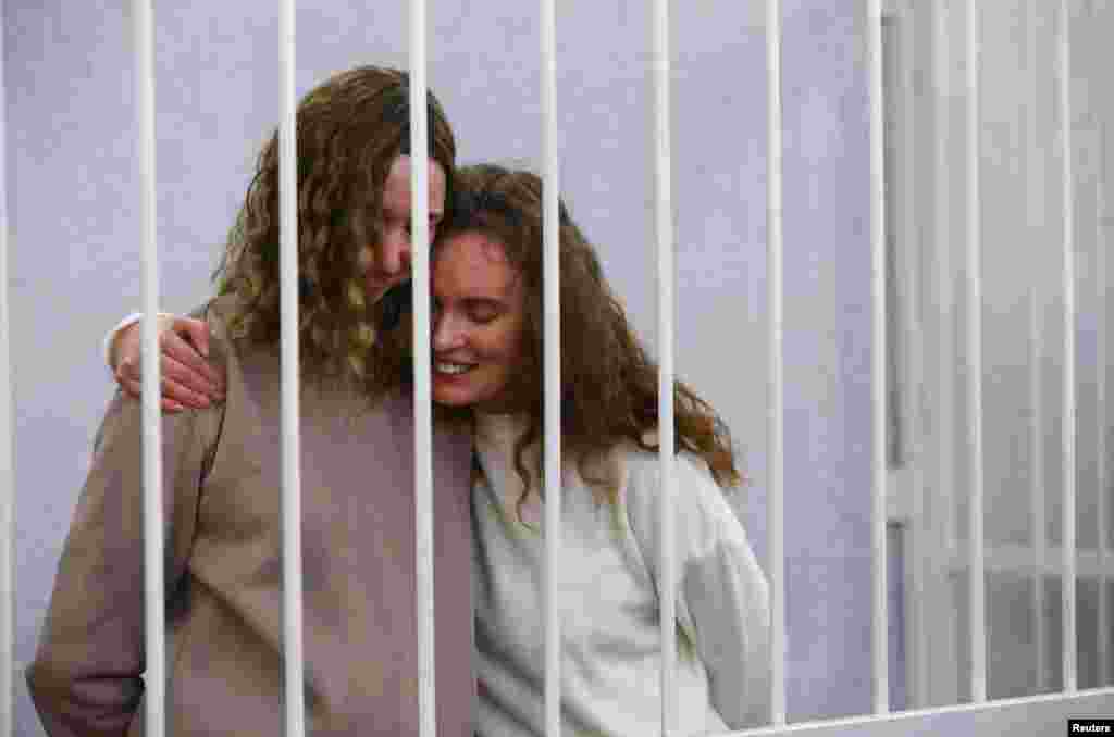 Yekaterina Andreeva and Darya Chultsova, journalists working for the Polish television channel Belsat accused of coordinating mass protests in 2020 by broadcasting live reports, embrace inside a defendants&#39; cage during a court hearing in Minsk, Belarus.