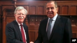 U.S. National Security Adviser John Bolton, left, and Russian Foreign Minister Sergey Lavrov shake hands prior to their talks in Moscow, Oct. 22, 2018. 