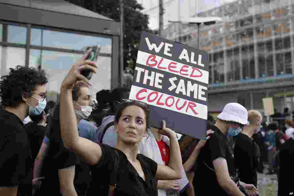 Protesters gather outside the Paris courthouse, Tuesday, June 2, 2020. Thousands of people ignored a police ban and met on the main Paris courthouse for a demonstration to show support for U.S. protesters as well as to denounce the death of a black man in 2016 shortly after French police arrested him.