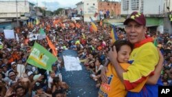 El candidato presidencial opositor venezolano Henri Falcon, (derecha) abraza a una partidaria durante su acto de cierre de campaña el jueves, 17 de mayo, de 2018, en Barquisimeto, Venezuela.