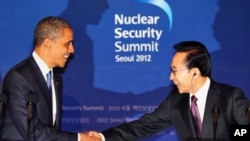 U.S. President Barack Obama, left, shakes hands with his South Korean counterpart Lee Myung-bak during a joint press conference following their meeting at the presidential Blue House in Seoul, South Korea, Sunday, March 25, 2012.