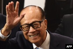 Hong Kong's richest man Li Ka-shing, 89, waves as he leaves a press conference in Hong Kong on March 16, 2018.