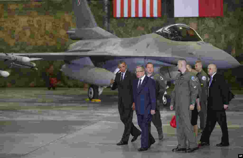 Presiden AS Barack Obama dan Presiden Polandia Bronislaw Komorowski berjalan untuk memberikan pernyataan setelah bertemu dengan prajurit AS dan Polandia di sebuah acara yang menampilkan jet tempur F-16 di Warsawa, 3 Juni 2014.