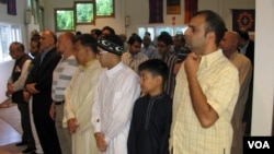 FILE - American Muslims offer Eid al-Fitr prayers in a community center in northern Virginia, Aug. 8, 2013. Muslims are relatively few in number in the U.S. but tend to live in swing states that can have an impact on election outcomes. (M. Elshinnawi/VOA)