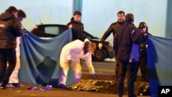 Italian police cordon off an area around a body after a shootout between police and a man in Milan's Sesto San Giovanni neighborhood, Italy, Dec. 23, 2016.