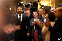 Journalists and supporters of Lebanese Prime Minister-designate Saad Hariri, left, clap as he arrives for a press conference, in Beirut, Lebanon, Nov. 13, 2018.