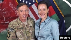 FILE - General David Petraeus, former CIA chief and commander of the International Security Assistance Force/U.S. Forces in Afghanistan, shakes hands with author Paula Broadwell in this handout photo from ISAF, originally posted July 13, 2011. 
