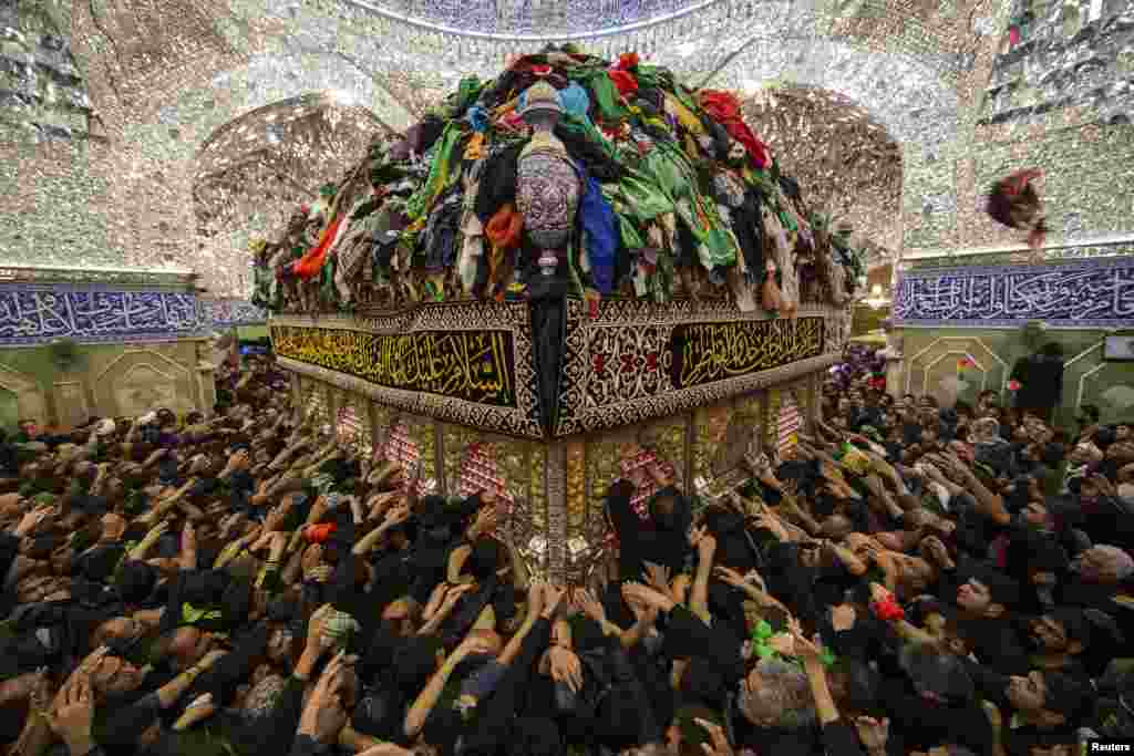Shi&#39;ite Muslim pilgrims reach out to touch the tomb of Imam al-Abbas located inside the Imam al-Abbas shrine to mark Arbain in the holy city of Karbala, southwest of Baghdad, Dec. 13, 2014.