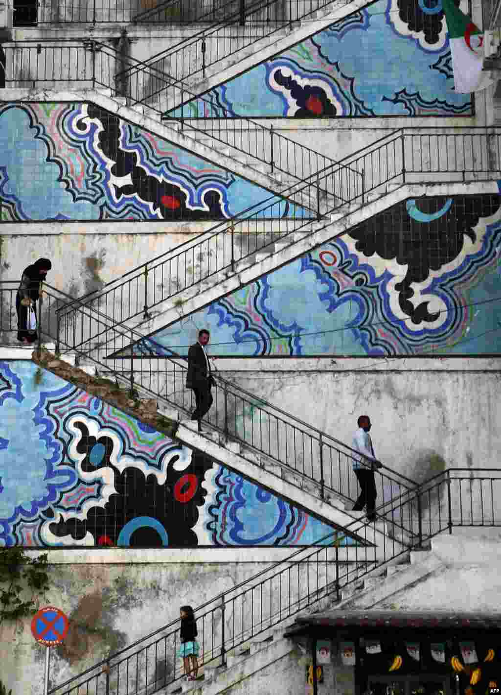 Algerians walk down decorated stairs in the center of the Algerian capital.