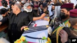 FILE - Members of an Iraqi Shiite militant group attend the funeral of a fighter with the Kataib Hezbollah, who was killed in a U.S. airstrike, in Baghdad, Iraq, January 25, 2024.