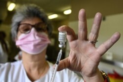 A nurse fills a syringe with a dose of the Pfizer-BioNTech COVID-19 vaccine at Zinga Zanga village hall vaccination center in Beziers, southern France, March 17, 2021.