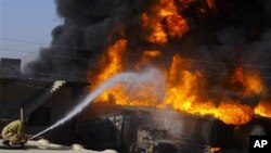 A Pakistani fire fighter tries to extinguish burning oil tankers after militants attacked a terminal in Quetta, Pakistan, 06 Oct 2010