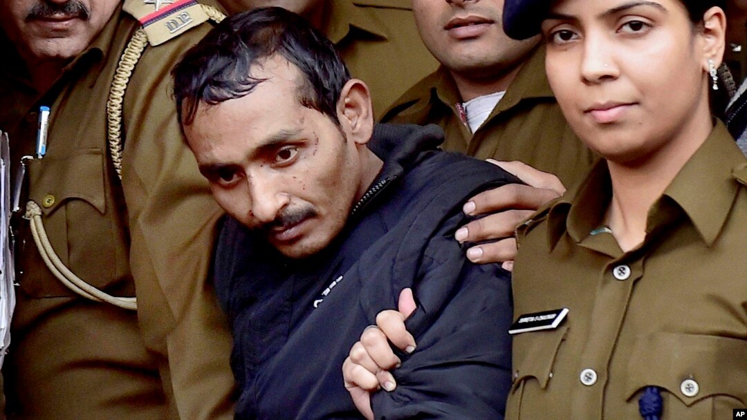 FILE - Shiv Kumar Yadav, 32 (c) a driver from the international taxi-booking service Uber, is surrounded by police as he is brought out after being produced in a court in New Delhi, India, Dec. 8, 2014. 