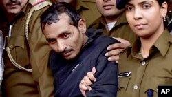 FILE - Shiv Kumar Yadav, 32 (c) a driver from the international taxi-booking service Uber, is surrounded by police as he is brought out after being produced in a court in New Delhi, India, Dec. 8, 2014. 