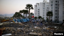 FILE - Residents cross among the rubble after a magnitude 8.3 earthquake hit areas of central Chile, in Coquimbo city, north of Santiago, Sept. 17, 2015. 