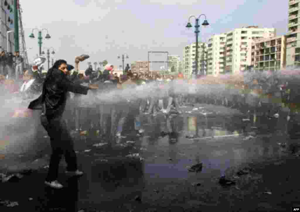 A demonstrator stands in front of police water canons during a protest in Cairo January 28, 2011. Police and demonstrators fought running battles on the streets of Cairo on Friday in a fourth day of unprecedented protests by tens of thousands of Egyptians