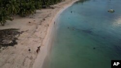 ARCHIVO - Un jinete pasea a caballo en la playa de la isla de San Andrés en Colombia, el 9 de noviembre de 2022.