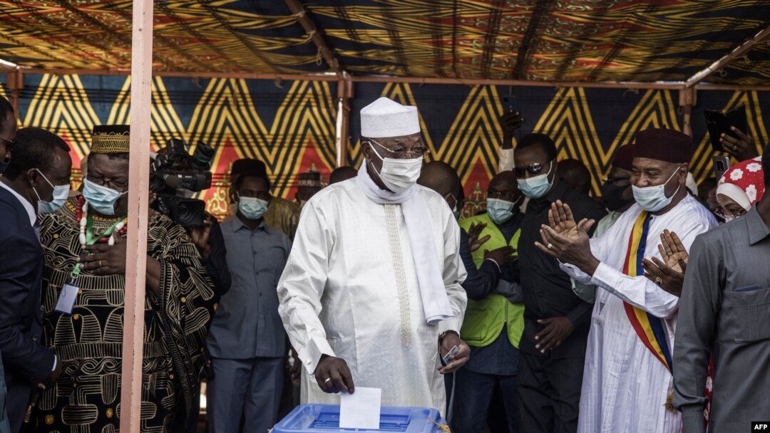 Chadian President Idriss Deby Itno (C) casts his ballot at a polling station in N'djamena, on April 11, 2021.
