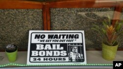 FILE - A sign is seen in the window of a bail bonds office across from the Hall of Justice in San Francisco, Dec. 23, 2015.