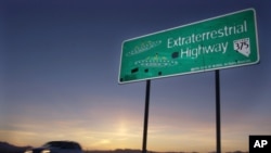 FILE - In this April 10, 2002, file photo, a car moves along the Extraterrestrial Highway near Rachel, Nev.