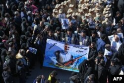 FILE - Iranian mourners gather during the final stage of funeral processions for slain top general Qassem Soleimani, in his hometown Kerman, Jan. 7, 2020.