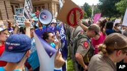 Anti-abortion advocates confront abortion rights advocates during the Women's March ATX rally, Oct., 2, 2021, at the Texas State Capitol in Austin, Texas. 