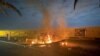 Burning debris is seen on a road near Baghdad International Airport, which according to Iraqi paramilitary groups was caused by three rockets hitting the airport, Jan. 3, 2020,