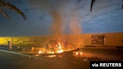 Burning debris is seen on a road near Baghdad International Airport, which according to Iraqi paramilitary groups was caused by three rockets hitting the airport, Jan. 3, 2020,