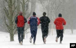 Joggers run together in the snow in Gladbeck, Germany, Sunday, Dec. 20, 2009. (AP Photo/Martin Meissner)